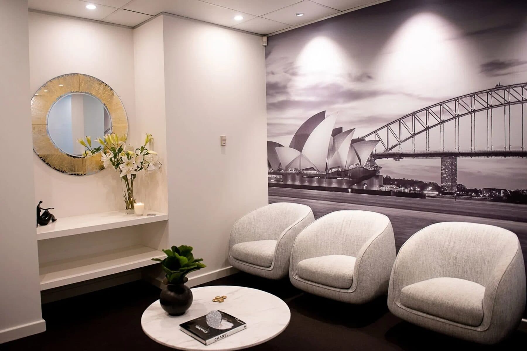 Waiting room at 60 Park Street, Sydney: three armchairs beneath a black-and-white mural of the Opera House and Harbour Bridge
